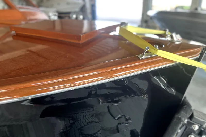 Slide: The Image of 1962 Prowler Forest Johnson boat with polished wood and yellow straps in a garage. - 39