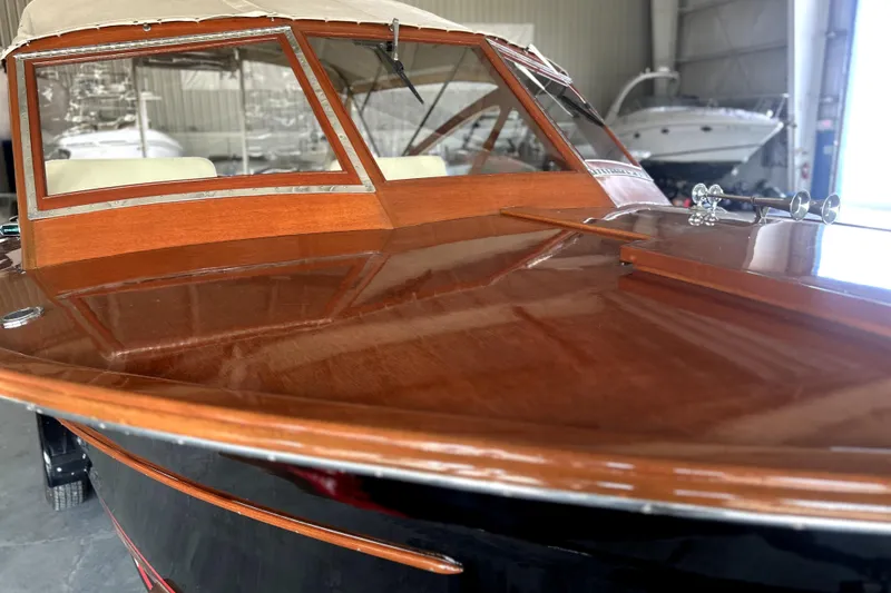Slide: The Image of 1962 Prowler Forest Johnson boat with polished wooden deck in a storage facility. - 40