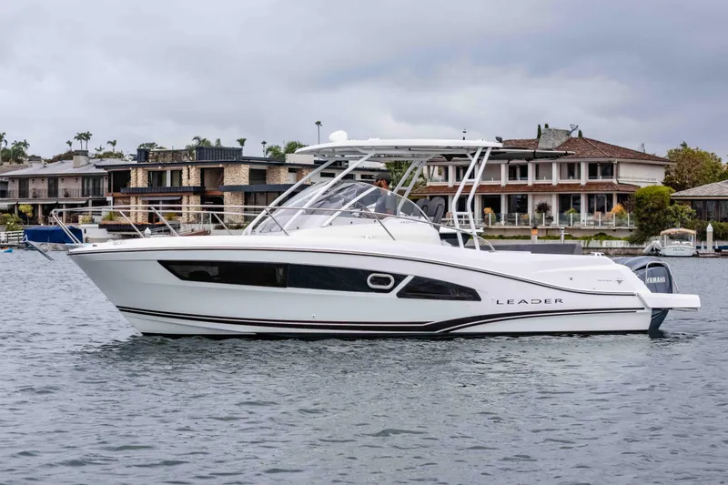 The Image of 2023 Jeanneau Leader 9.0 WA boat on water, with waterfront homes in background. - 0