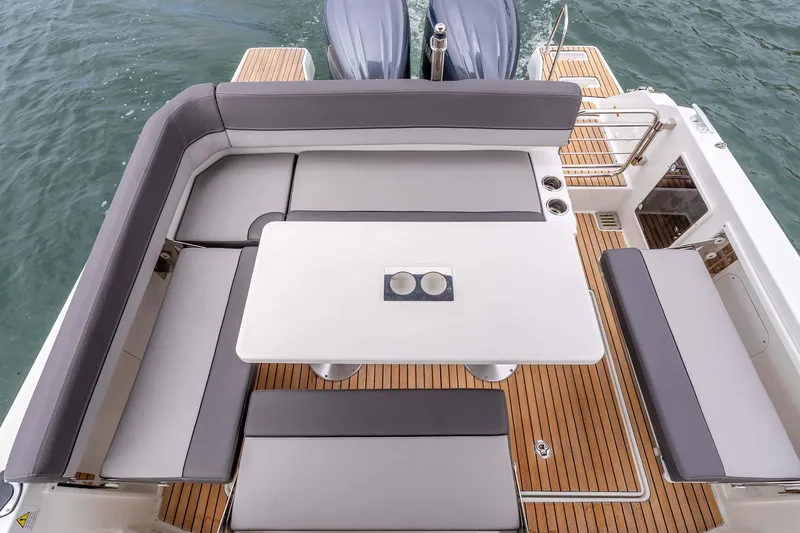 Slide: The Image of 2023 Jeanneau Leader 9.0 WA boat interior with cushioned seating and table. - 10
