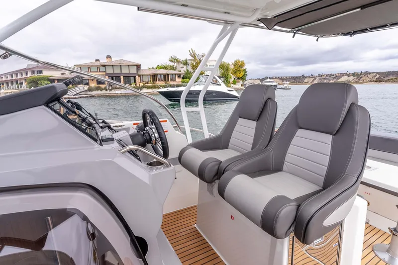 Slide: The Image of 2023 Jeanneau Leader 9.0 WA boat interior with dual seats and steering console. - 14