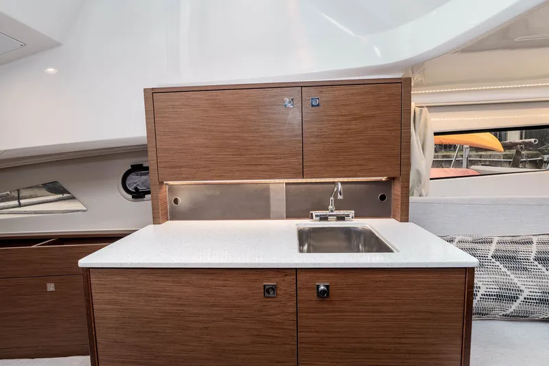 Slide: The Image of Modern kitchenette in 2023 Jeanneau Leader 9.0 WA boat with wood cabinetry and stainless steel sink. - 19