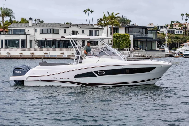Slide: The Image of 2023 Jeanneau Leader 9.0 WA boat cruising near waterfront homes. - 4