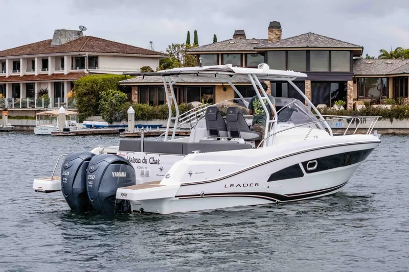 Slide: The Image of 2023 Jeanneau Leader 9.0 WA boat with twin Yamaha engines on a calm waterfront. - 5