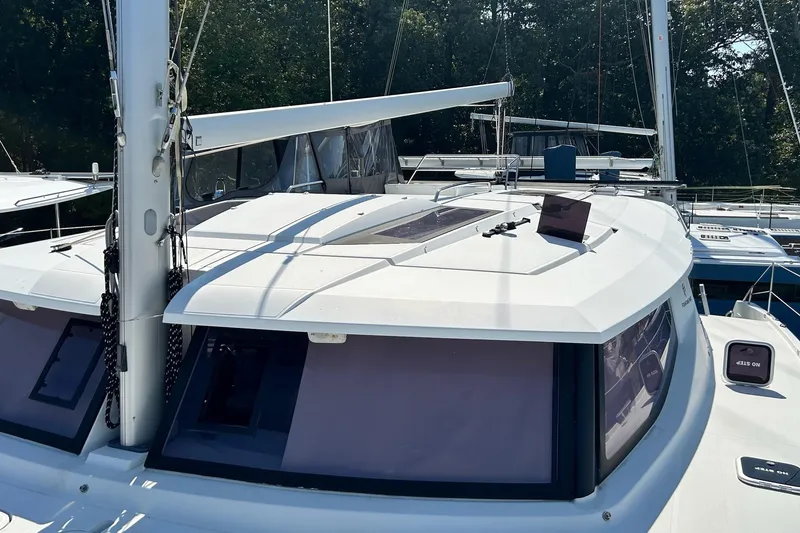 Slide: The Image of 2019 Fountaine Pajot Helia 44 Evolution catamaran, docked with visible sails and windows. - 2