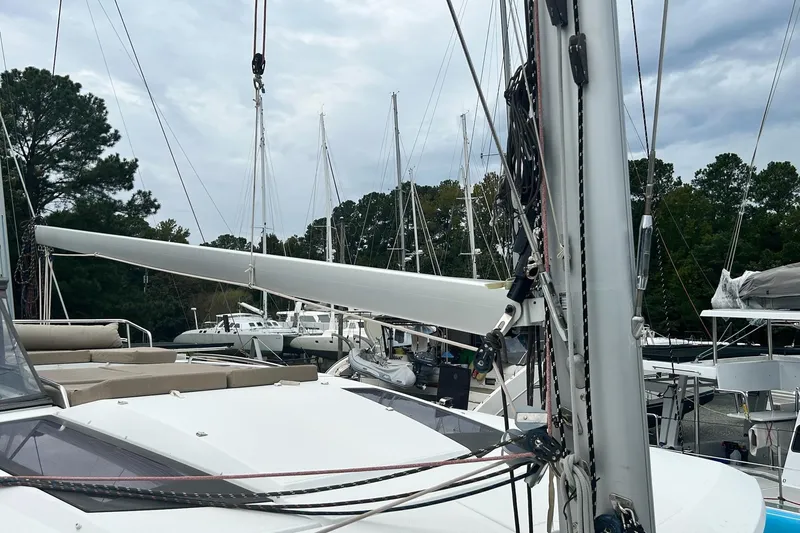 Slide: The Image of 2019 Fountaine Pajot Helia 44 Evolution catamaran docked, surrounded by trees and other boats. - 40