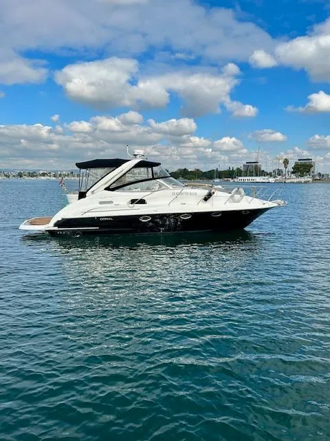 Slide: The Image of 2006 Doral Elegante boat on calm water under a partly cloudy sky. - 1