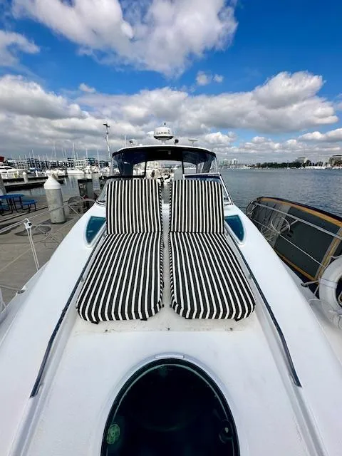 Slide: The Image of 2006 Doral Elegante yacht with striped sun loungers, docked at marina under blue sky. - 11