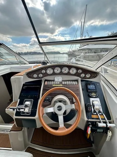 Slide: The Image of 2006 Doral Elegante boat dashboard with wooden steering wheel and control panel. - 13