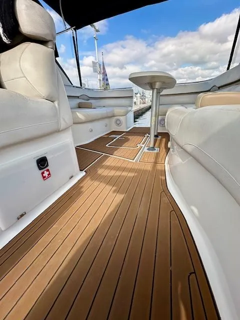 Slide: The Image of 2006 Doral Elegante boat interior with wooden deck and white seating under blue sky. - 19