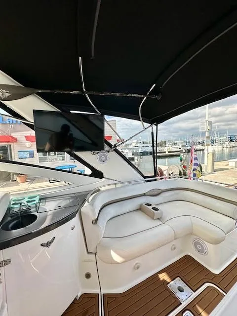 Slide: The Image of 2006 Doral Elegante yacht interior with white seating, TV, and marina view. - 28