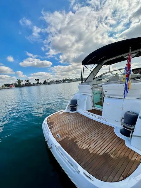Slide: The Image of 2006 Doral Elegante yacht on calm water, wooden deck, clear sky, and flags displayed. - 30