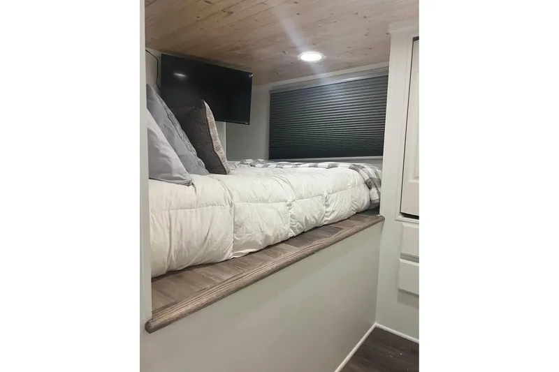 Slide: The Image of Cozy bedroom in 1999 Sharpe houseboat with TV, wood ceiling, and modern decor. - 14