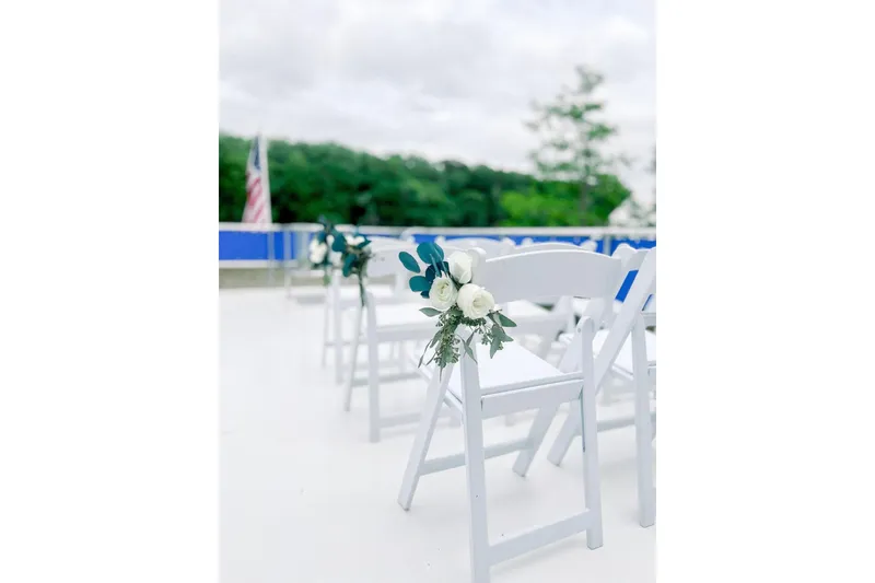 Slide: The Image of White chairs with floral decorations on a 1999 Sharpe houseboat deck. - 17