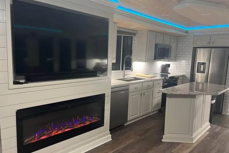 Slide: The Image of Modern kitchen in a 1999 Sharpe houseboat with sleek appliances and ambient lighting. - 18
