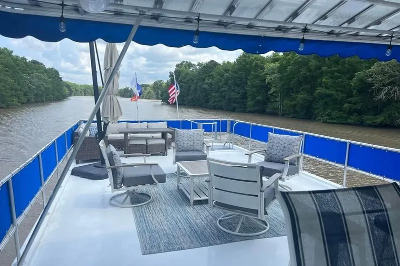 Slide: The Image of Rooftop deck of 1999 Sharpe houseboat with seating, flags, and river view. - 2