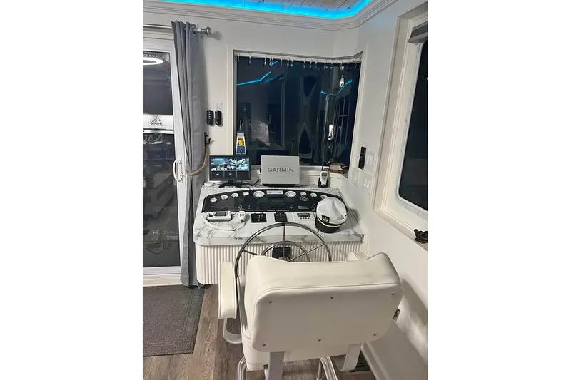 Slide: The Image of 1999 Sharpe houseboat helm with Garmin navigation, white captain's chair, and modern controls. - 4