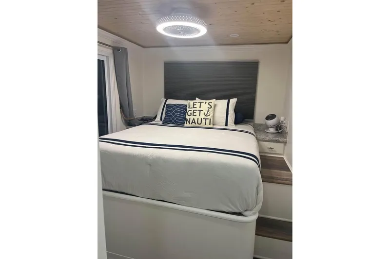 Slide: The Image of Cozy bedroom in a 1999 Sharpe houseboat with nautical-themed decor and modern lighting. - 8