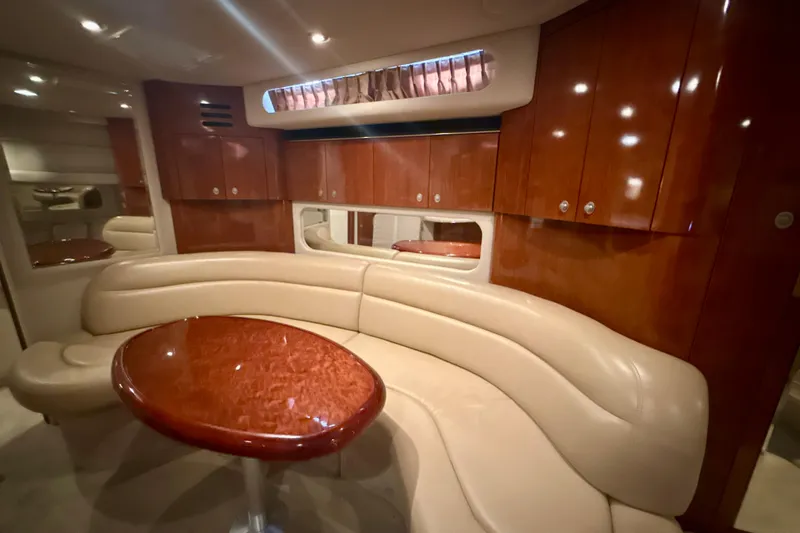 Slide: The Image of Luxurious interior of 2004 Sea Ray 380 Sundancer with leather seating and polished wood table. - 24
