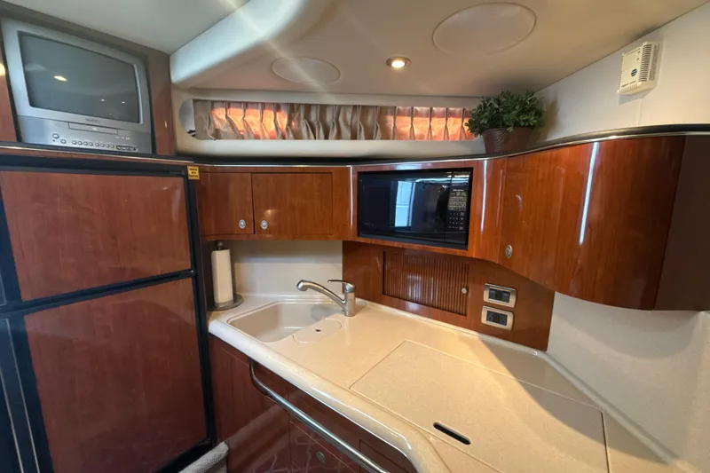 Slide: The Image of Luxurious 2004 Sea Ray 380 Sundancer yacht kitchen with wood cabinets and modern appliances. - 31