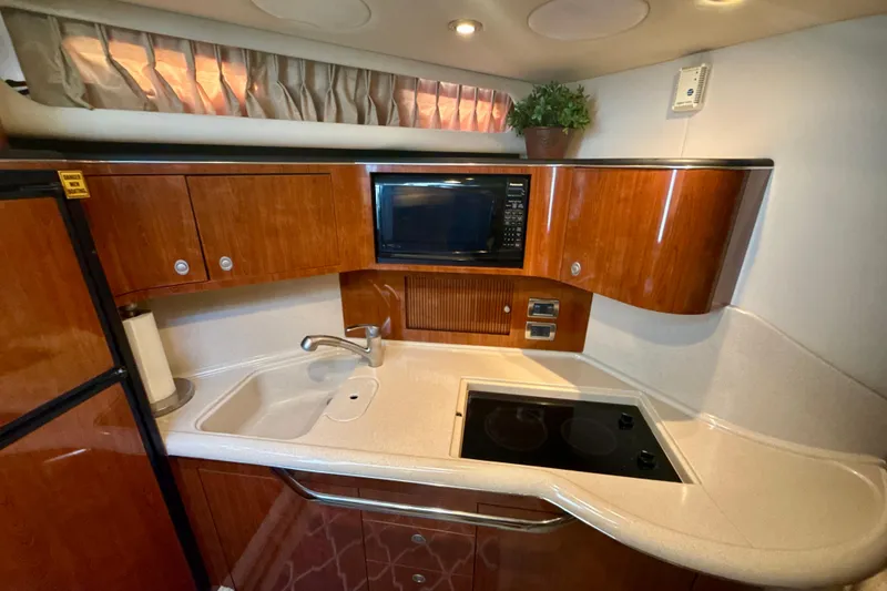 Slide: The Image of Luxurious 2004 Sea Ray 380 Sundancer yacht kitchen with wood cabinets and modern appliances. - 32