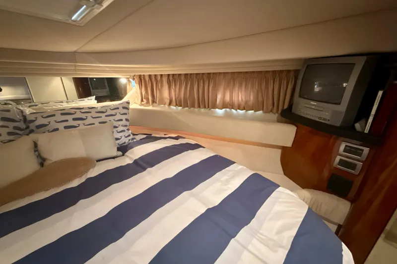 Slide: The Image of 2004 Sea Ray 380 Sundancer cabin with striped bedding and vintage TV. - 34