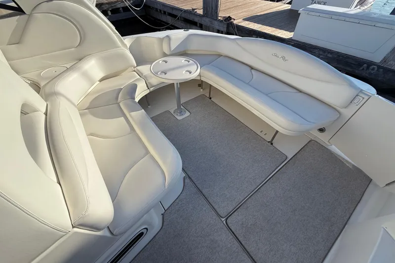 Slide: The Image of 2004 Sea Ray 380 Sundancer boat interior with white seating and small round table. - 6