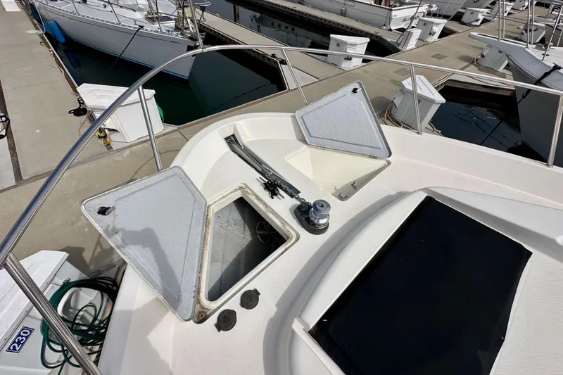 Slide: The Image of 2004 Meridian 580 Pilothouse yacht deck with open storage compartments at marina. - 102
