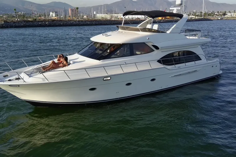 Slide: The Image of 2004 Meridian 580 Pilothouse yacht cruising with passengers, scenic coastal backdrop. - 11