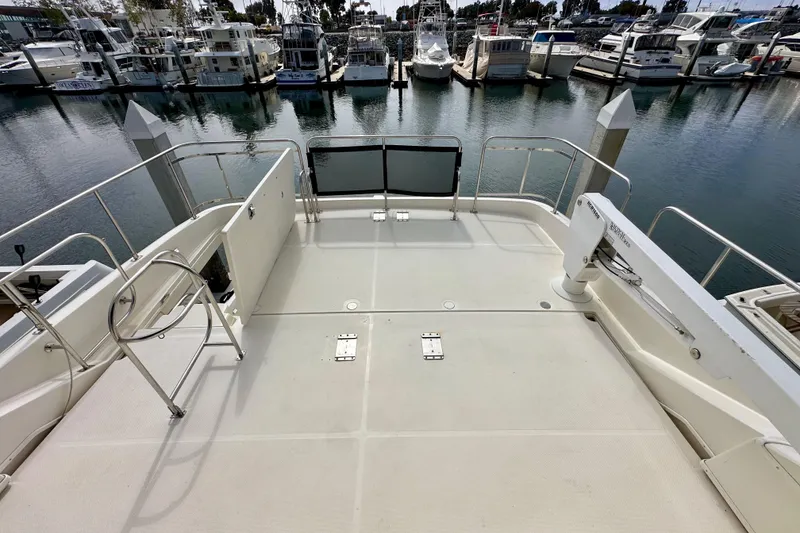 Slide: The Image of 2004 Meridian 580 Pilothouse yacht deck with marina view, featuring sleek railings and spacious layout. - 112