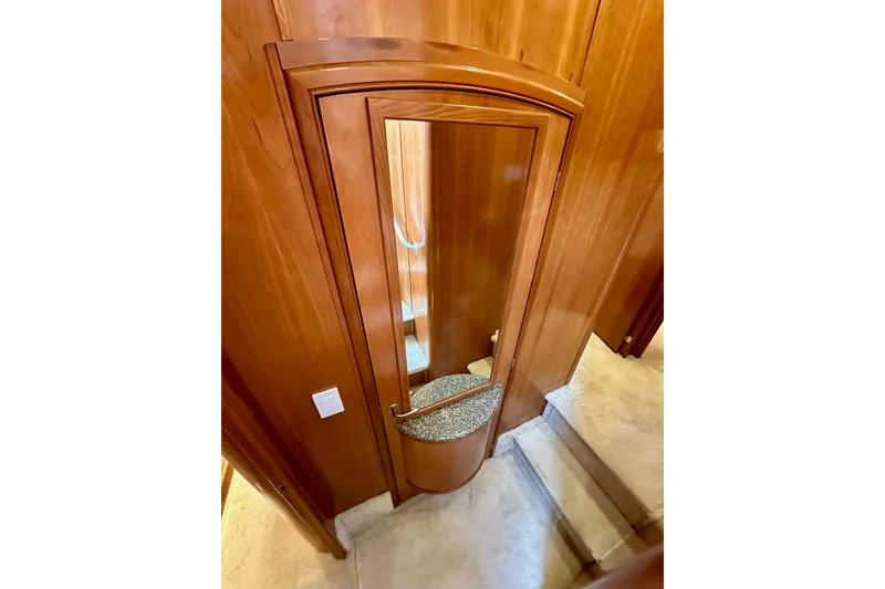 Slide: The Image of Wooden interior of 2004 Meridian 580 Pilothouse yacht with mirrored door and carpeted stairs. - 129
