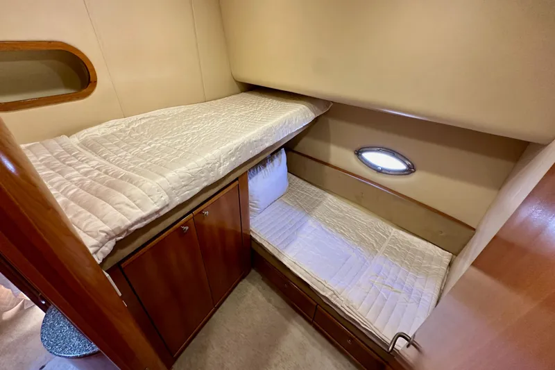 Slide: The Image of 2004 Meridian 580 Pilothouse cabin with bunk beds and wooden cabinetry. - 141