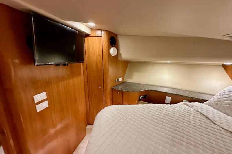 Slide: The Image of Luxurious cabin interior of 2004 Meridian 580 Pilothouse yacht with TV and wood paneling. - 148