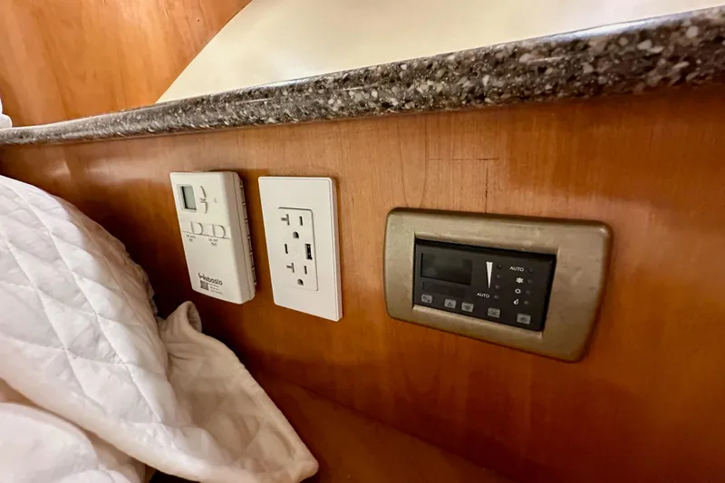 Slide: The Image of Control panel and outlets in 2004 Meridian 580 Pilothouse interior, featuring wood and granite finishes. - 153