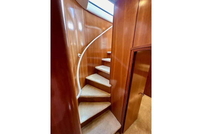 Slide: The Image of Curved staircase inside 2004 Meridian 580 Pilothouse yacht with wooden paneling. - 159