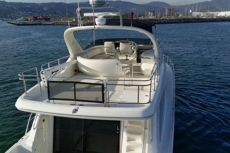 Slide: The Image of 2004 Meridian 580 Pilothouse yacht on calm water, showcasing upper deck and helm. - 7