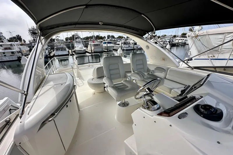 Slide: The Image of 2004 Meridian 580 Pilothouse yacht interior with helm, seating, and marina view. - 71