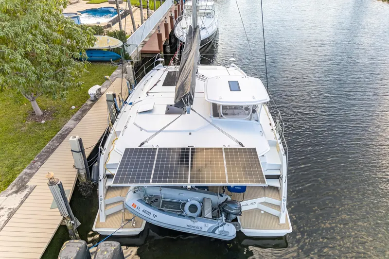 Slide: The Image of 2020 Leopard 40 catamaran docked, featuring solar panels and a small boat. - 10