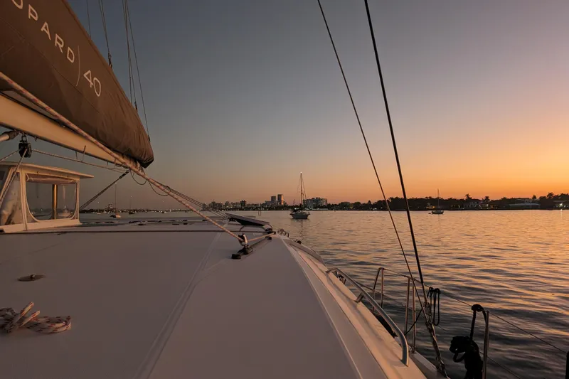 Slide: The Image of Leopard 40 catamaran sailing at sunset, calm waters, city skyline in background. - 109