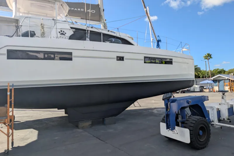 Slide: The Image of 2020 Leopard 40 catamaran on dry dock, with blue sky and palm trees in the background. - 113