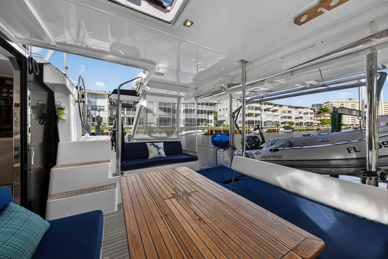Slide: The Image of Spacious deck of 2020 Leopard 40 catamaran with wooden table and marina view. - 15