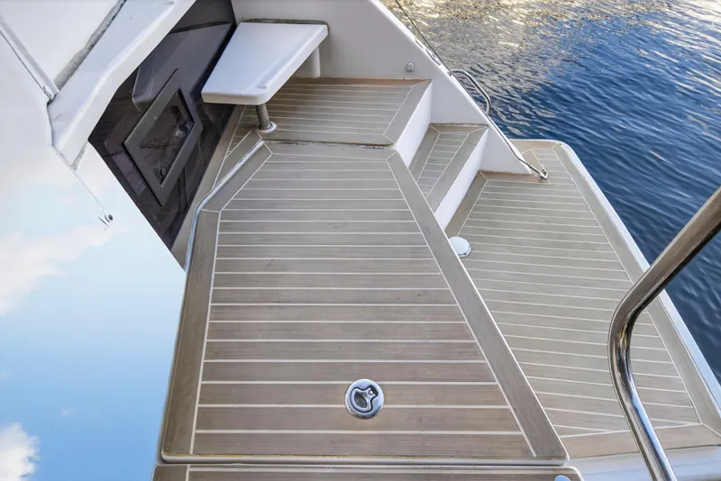 Slide: The Image of Leopard 40 yacht deck, 2020 model, featuring sleek wooden flooring and water reflection. - 24