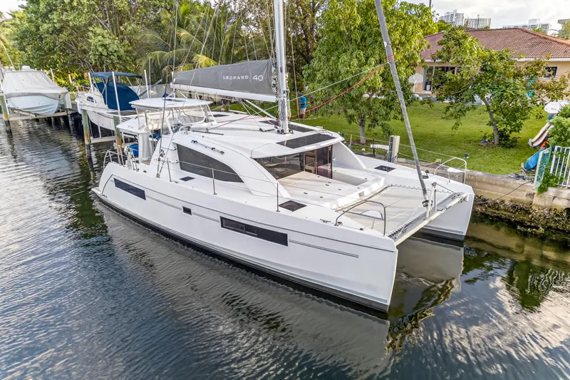Slide: The Image of 2020 Leopard 40 catamaran docked in a serene canal setting. - 3