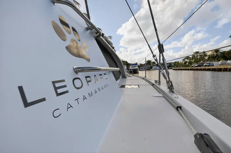 Slide: The Image of Leopard 40 catamaran, 2020 model, docked by a scenic waterfront under a cloudy sky. - 35