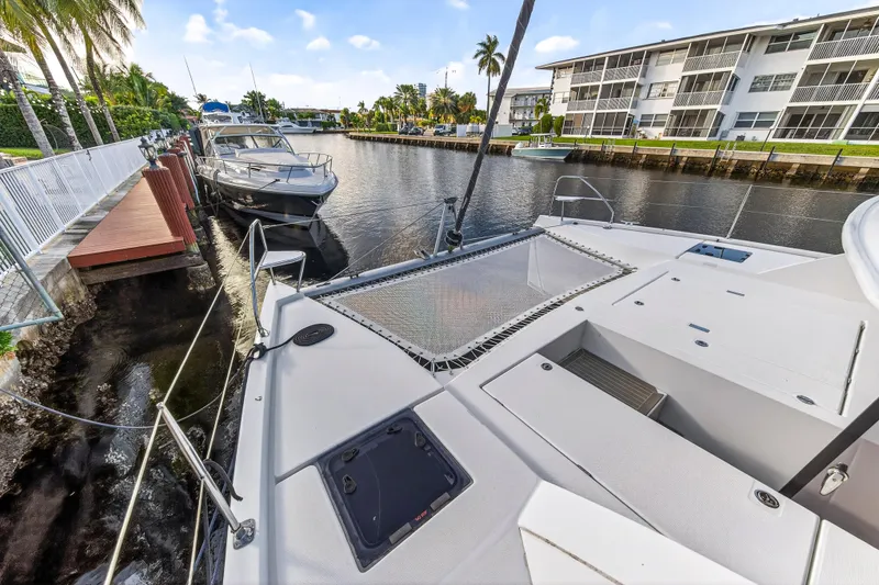 Slide: The Image of Leopard 40 catamaran docked in a scenic canal, surrounded by palm trees and modern buildings. - 37