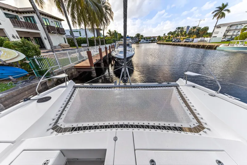 Slide: The Image of Front view of a 2020 Leopard 40 catamaran docked in a scenic canal. - 38