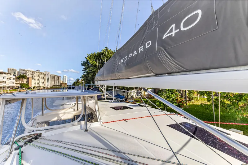 Slide: The Image of 2020 Leopard 40 catamaran docked near waterfront buildings and lush greenery. - 47