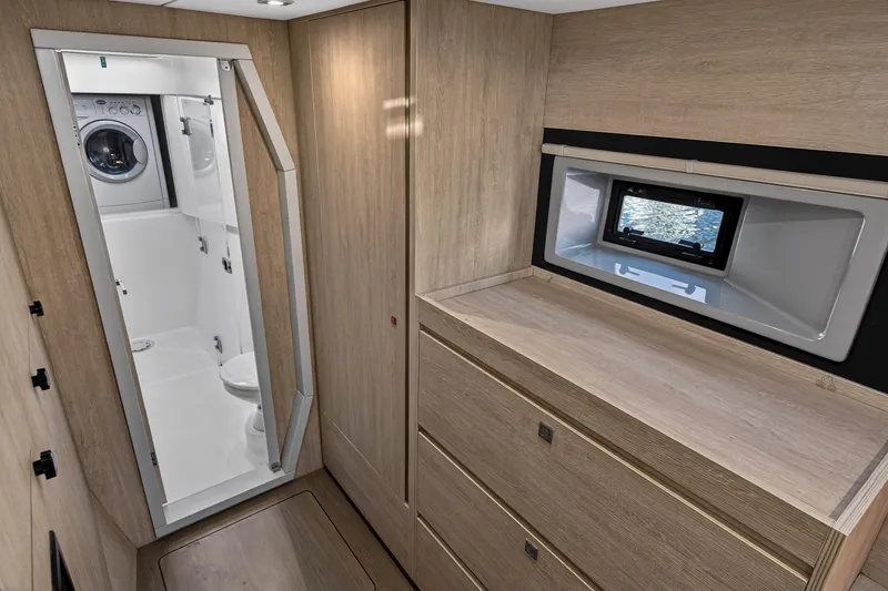 Slide: The Image of Modern Leopard 40 yacht interior with wood finish, featuring a compact bathroom and washing machine. - 88