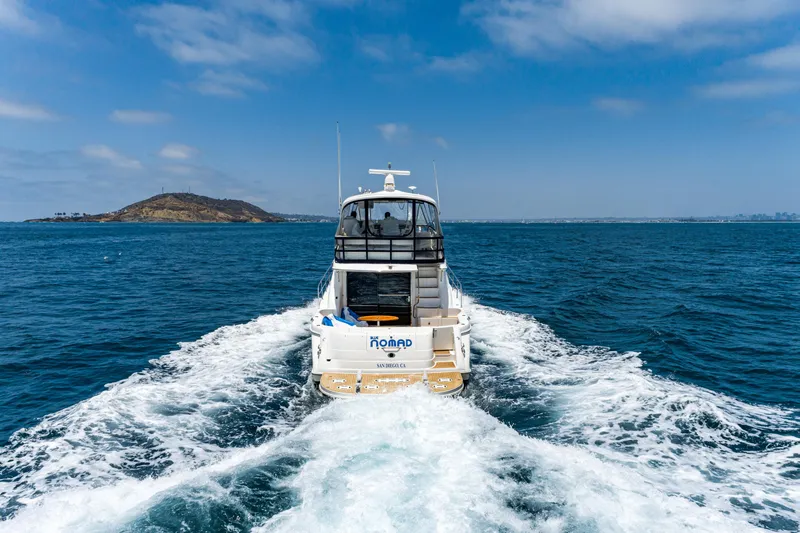 Slide: The Image of 2001 Sea Ray 560 Sedan Bridge cruising on open water under a clear blue sky. - 12