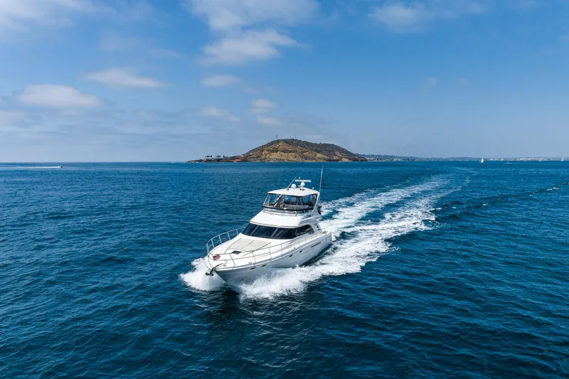 Slide: The Image of 2001 Sea Ray 560 Sedan Bridge yacht cruising on open blue water. - 18